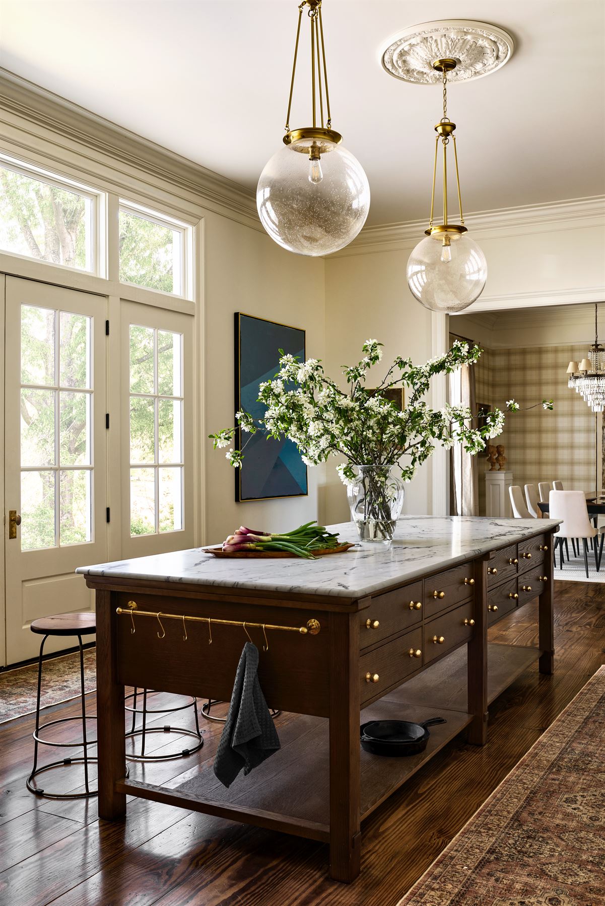 Kitchen with a walnut island, marble top and glass pendant lights