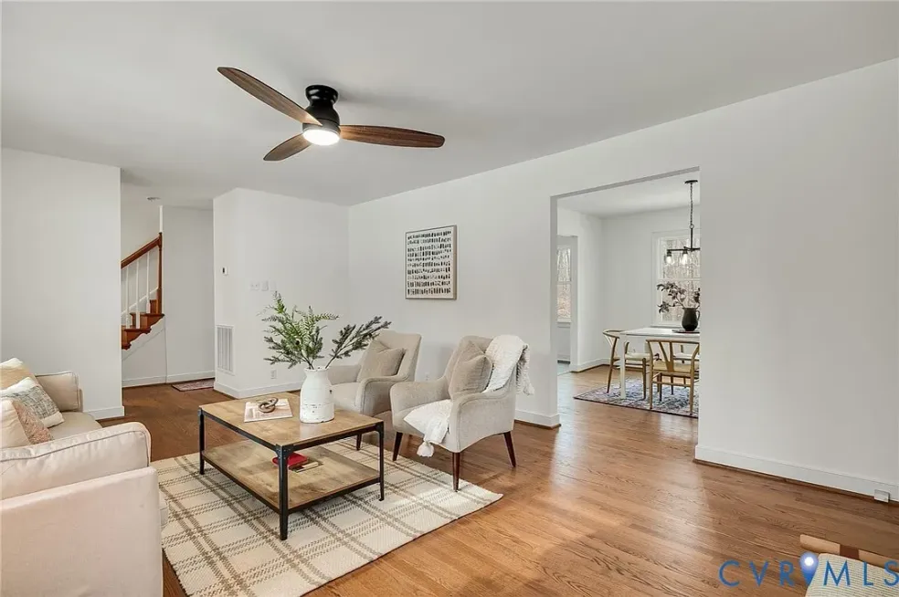 Open living room with hardwood floors leading to a dining room